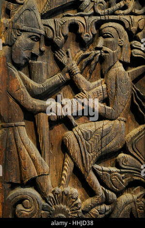 Norway. Setesdal. Hylestad church. Stave-church portal.  c. 1200. Carved on the panels are scenes from the 'Sigurd Favnesbane' stories. Relief carving in wood and depicting Sigurd kills Regin with his sword. Historical Museum. Oslo. Norway. Stock Photo