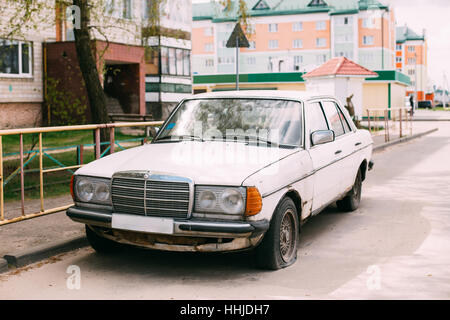 Old rusty car 1980 Mercedes-Benz 300 D (W123) sedan parking on street. The Mercedes W123 is a range of executive cars produced by German manufacturer Stock Photo