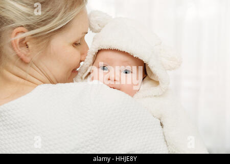 happy mother with infant baby girl dressed in white fluffy costume Stock Photo