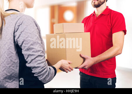 woman accepting a delivery of boxes from delivery service courier Stock Photo