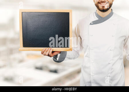 chef cook holding blank blackboard in hand Stock Photo