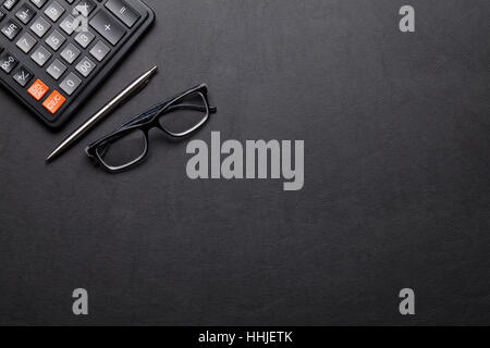 Office leather desk table with calculator, pen and glasses. Top view with copy space Stock Photo