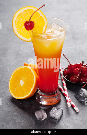 Tequila sunrise cocktail on dark stone table. With space for your text ...