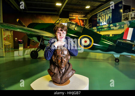 Eachan Hardie, 12, with a bust of Captain Eric &Ograve;Winkle&Oacute; Brown, a WWII pilot who holds the world record for the most aircraft carrier take-offs (2,407) and the most landings (2,271), and on 3rd December 1945, and became the first ever pilot to take off and land a jet aircraft, a Sea Vampire, onto an aircraft carrier, at The National Museum of the Royal Navy at the Fleet Air Arm Museum, Yeovil, Somerset. Stock Photo