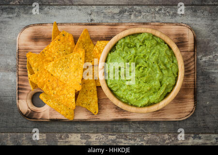 Nachos, guacamole and ingredients on wooden background Stock Photo