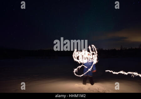 man creating shape with handheld fireworks sparkle Stock Photo