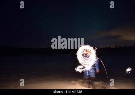 man creating shape with handheld fireworks sparkle Stock Photo