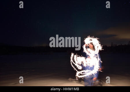 man creating shape with handheld fireworks sparkle Stock Photo