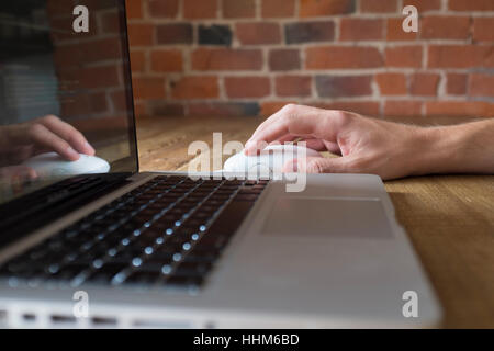 Hand using computer mouse with laptop Stock Photo