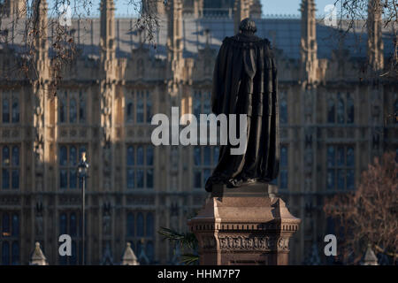 The monument to Benjamin Disraeli, Earl of Beaconsfield with the British Houses of Parliament in the background, on 18th January 2017, in Parliament Square, London England. The statue of Benjamin Disraeli is an outdoor bronze sculpture by Mario Raggi, located at Parliament Square in London, United Kingdom. Installed in 1883, it features a bronze statue on a red granite plinth. The memorial is located at the west side of the square, facing the Houses of Parliament, and is Grade II-listed. Stock Photo