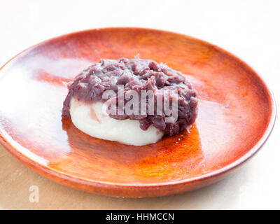 Japanese cuisine, a rice cake with sweet red beans paste on the wooden plate Stock Photo