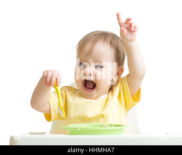 Baby girl eating her dinner isolated on white Stock Photo