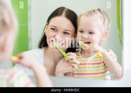 Mother And Child Daughter Brushing Teeth Together Stock Photo