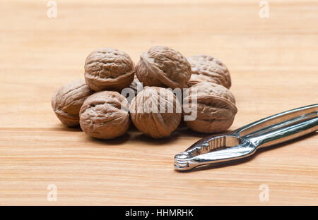 Walnuts (Juglans regia) in a wooden bowl on a wooden table Stock Photo
