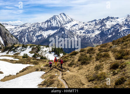 Hikers on trail to Twenger Almsee, mountains in the spring with residual snow, Obertauern, Radstadt Tauern, Salzburg State Stock Photo
