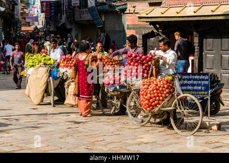 Fruit sellers, using bicycles, are offering apples and oranges on Indra Chowk market square, Kathmandu, Kathmandu District Stock Photo