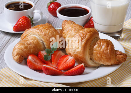 Croissants with strawberry, coffee and milk - healthy and wholesome breakfast Stock Photo
