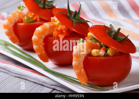 tomatoes filled with shrimp, rice and vegetables closeup. horizontal Stock Photo