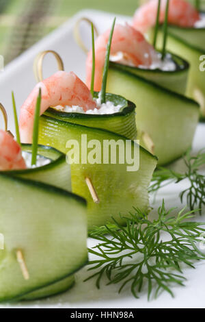 fresh cucumber rolls with shrimp and cheese on white plate macro vertical. Stock Photo