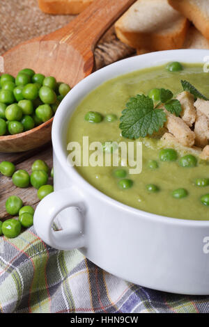 Soup puree of fresh green peas and croutons macro. vertical Stock Photo