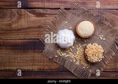 garlic cloves, bulb, flakes and powder on old wooden board Stock Photo