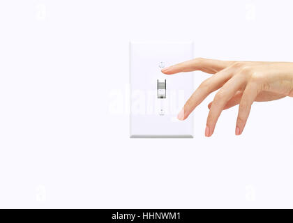 Hand of woman pressing light switch Stock Photo