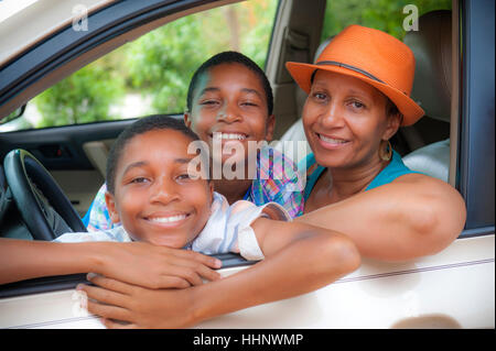 Portrait of mother and twin sons leaning on car window Stock Photo