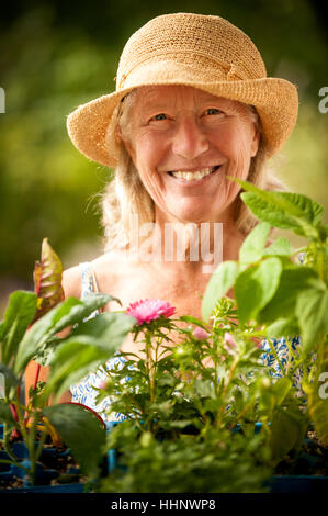 Portrait of smiling Caucasian woman holding tray of flowers Stock Photo