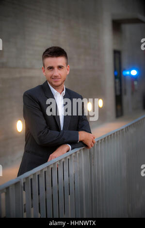 Portrait of smiling businessman leaning on railing Stock Photo