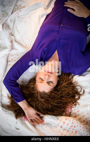 Caucasian woman sleeping on bed Stock Photo