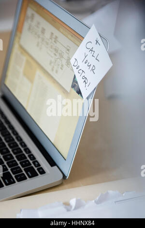 Reminder on adhesive note attached to laptop Stock Photo