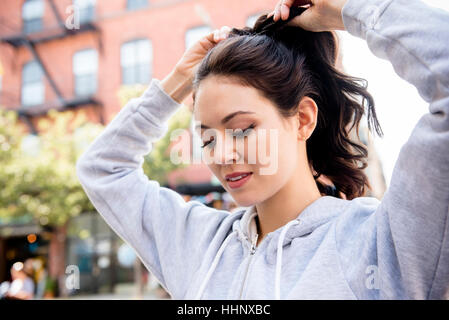 Thai woman tying hair in ponytail Stock Photo