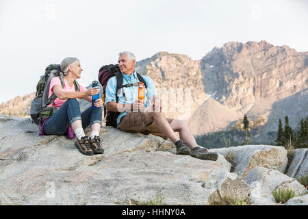 Caucasian couple resting on mountain Stock Photo
