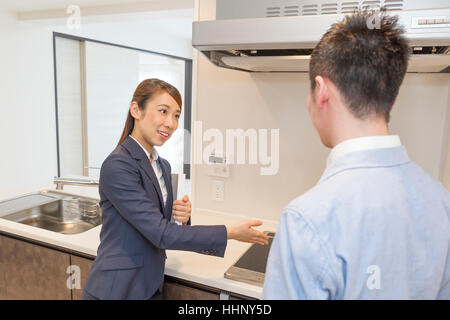 Real Estate Agent Showing Kitchen to Buyer Stock Photo