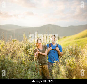 Portrait of Caucasian couple hiking on hill Stock Photo