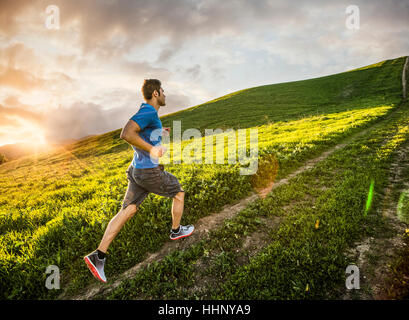 Hispanic man running on hill Stock Photo