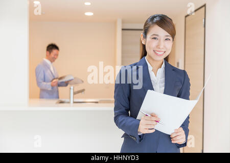 Woman Smiling to the Camera with Floor Plan Stock Photo