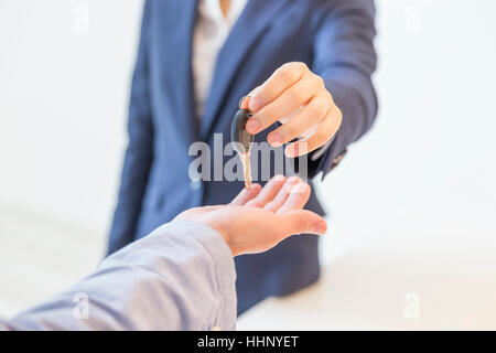 Woman Handing Key over to A Man Stock Photo