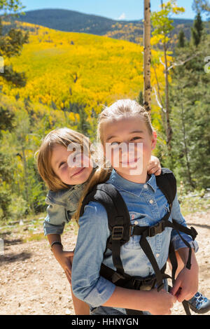 Caucasian girl carrying brother on back Stock Photo