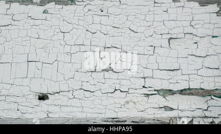 Thick white peeling crackled paint with green underneath.  On an old outbuilding on a farm. Stock Photo