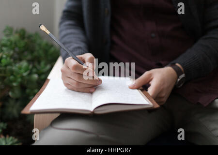 Young man writing in his journal Stock Photo
