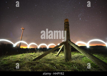 Glyndebourne, UK. 19th January, 2017. Starlight and a mobile phone were used to illuminate Mill Plain on the South Downs, where the remains of an eighteenth century post mill stand alongside the modern wind turbne that helps power world famous Glyndebourne Opera House. Credit: Peter Cripps/Alamy Live News Stock Photo