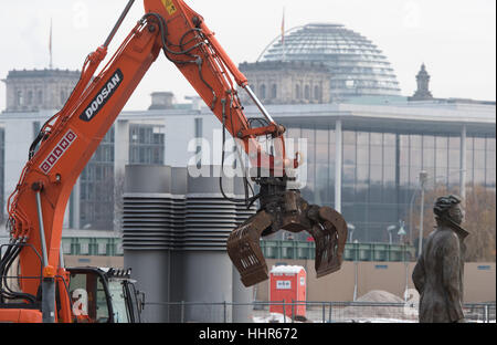 Berlin, Germany. 19th Jan, 2017. An excavator works at the construction site outside the main railway station behind the sculpture 'Partenza (Departure)' by Italian artist Giampaolo Talani in Berlin, Germany, 19 January 2017. The 'Cube' office building in the shape of a giant cube will be erected on Washingtonplatz square. The glass cube is a design from the Danish architecture office 3XN. Photo: Soeren Stache/dpa-Zentralbild/ZB/dpa/Alamy Live News Stock Photo