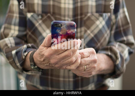 Man in Brown Plaid Shirt Holding iPhone Face On Stock Photo