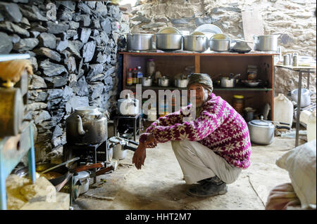 Indian man preparing tea and other hot drinks in a typical rudimentary coffee shop in the Himalayas, India Stock Photo