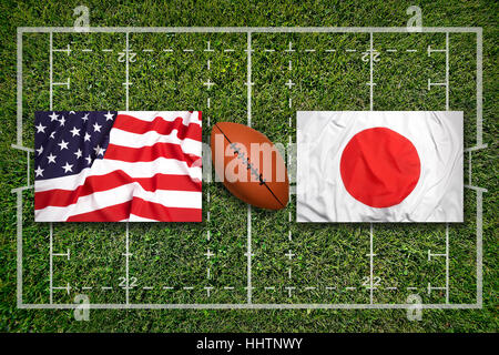 USA vs. Japan flags on green rugby field Stock Photo