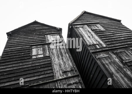 Old wooden black fishermens huts on a seafront at Hastings, East Sussex, England, UK Stock Photo