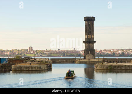 A barge leaves Salisbury Dock overlooked by the Gothic Victoria Tower, a Grade II listed Gothic Revival clock tower, Liverpool Stock Photo