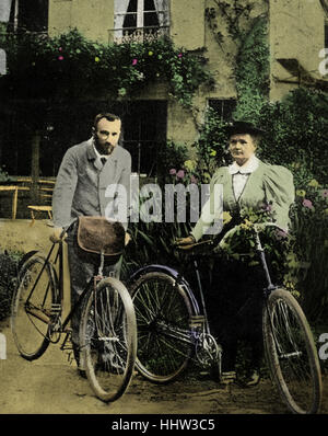 Pierre and Marie Curie with the bicycles on which, during their early married life, the roamed the roads of France together. MC: Polish-born French physicist and pioneer in radioactivity, 7 November 1867 – 4 July 1934. PC: French physicist and pioneer in radioactivity, 15 May 1859 – 19 April 1906. Stock Photo