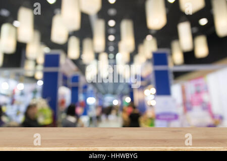 trade fair in exhibition hall, booth selling cheap goods from the manufacturer with selected focus wood table for display your product Stock Photo